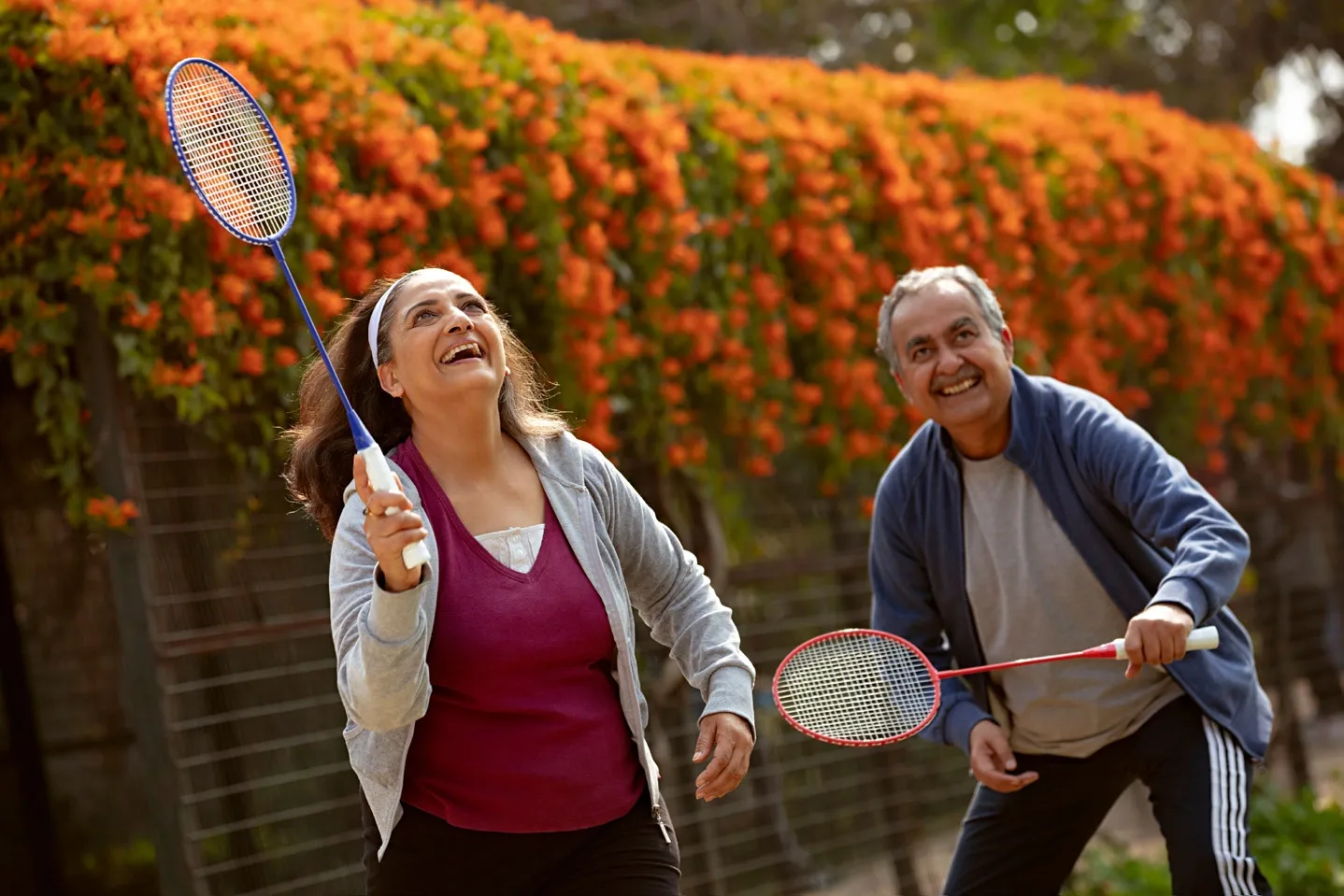 An older couple playing badminton outdoors